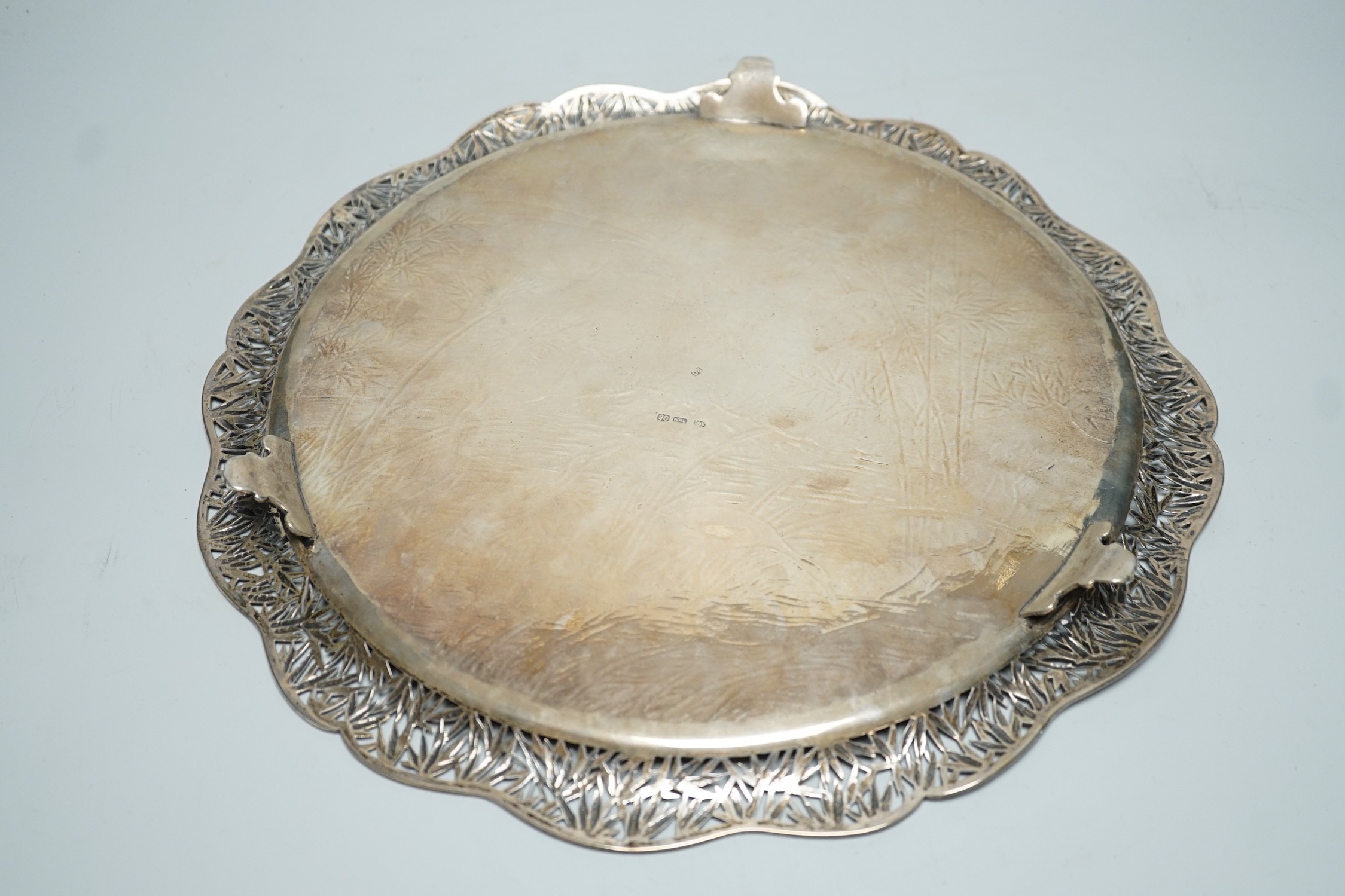 A Chinese Export white metal circular salver with pierced foliate wavy border and engraved with birds amongst reeds and bamboo, maker's mark, WHL, 33.7cm, 36oz.